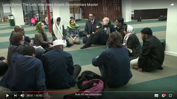 Lorna Byrne (iförd grön sjal) berättar om änglarna och bönens betydelse i en amerikansk moské. Skärmdump